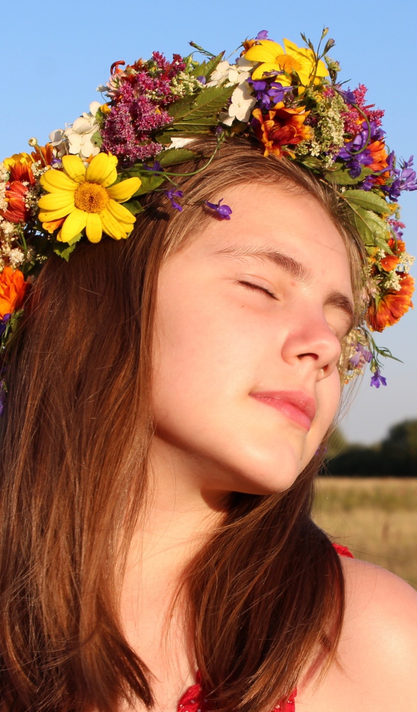 Girl with closed eyes with a wreath on her head