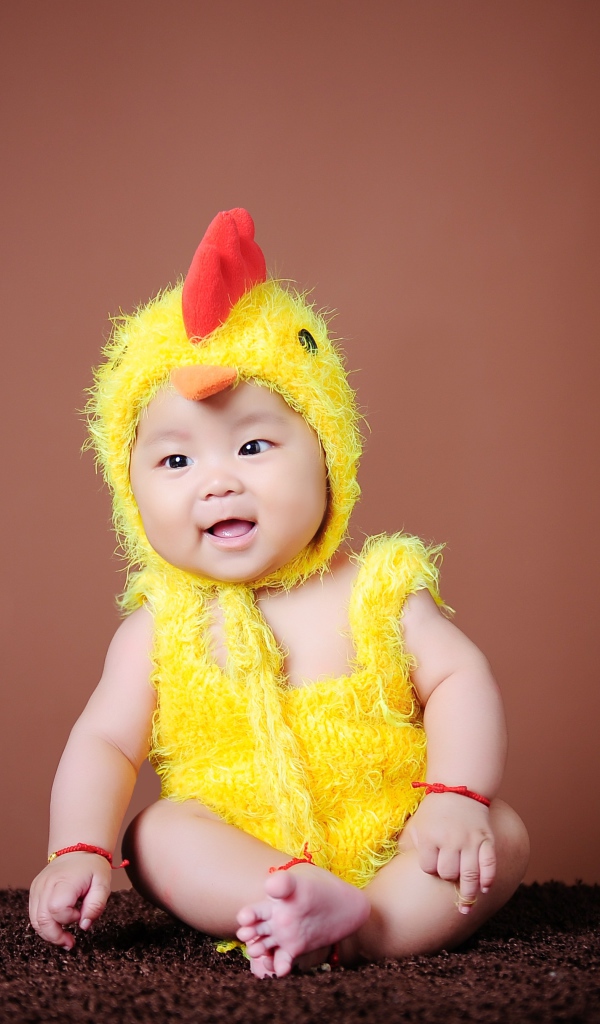 Маленький мальчик азиат в костюме цыпленка