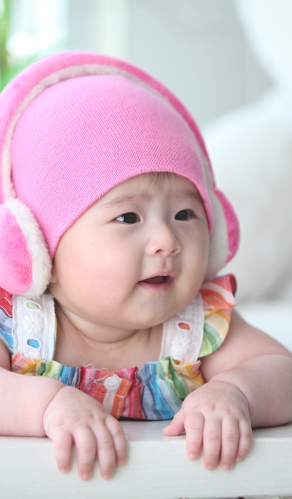 Маленький ребенок азиат в розовой шапке 