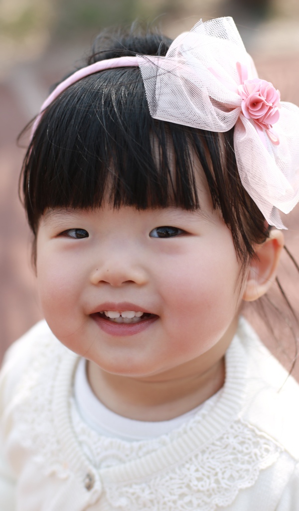Маленькая девочка азиатка с бантом на голове 