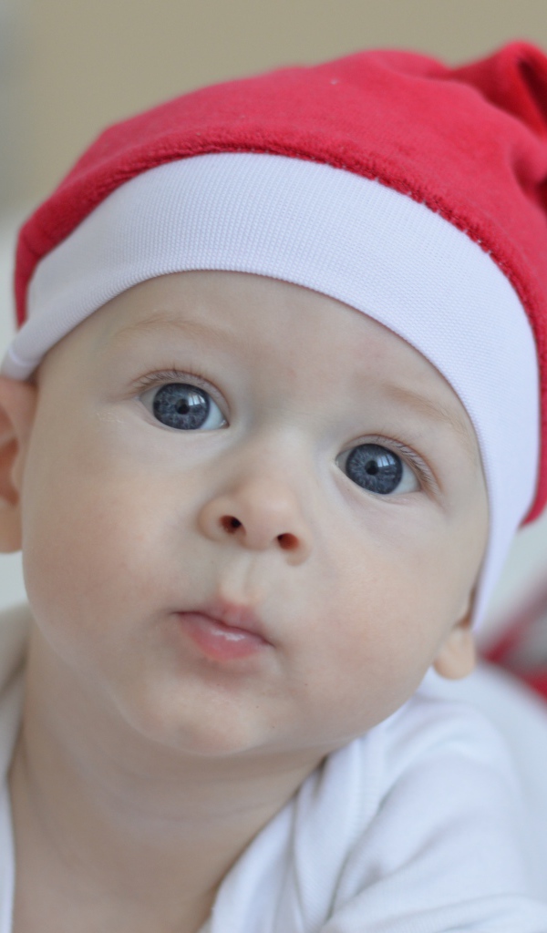 Маленький голубоглазый мальчик в красной шапке Санты