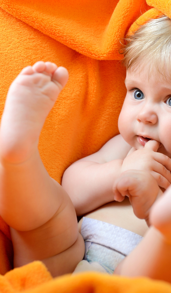 Маленький голубоглазый ребенок в желтом покрывале 