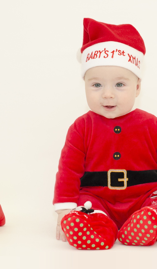 Маленький мальчик в новогоднем костюме на белом фоне