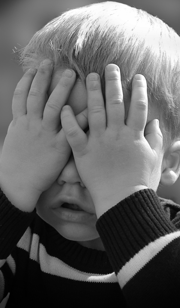 Маленький ребенок закрыл глаза руками