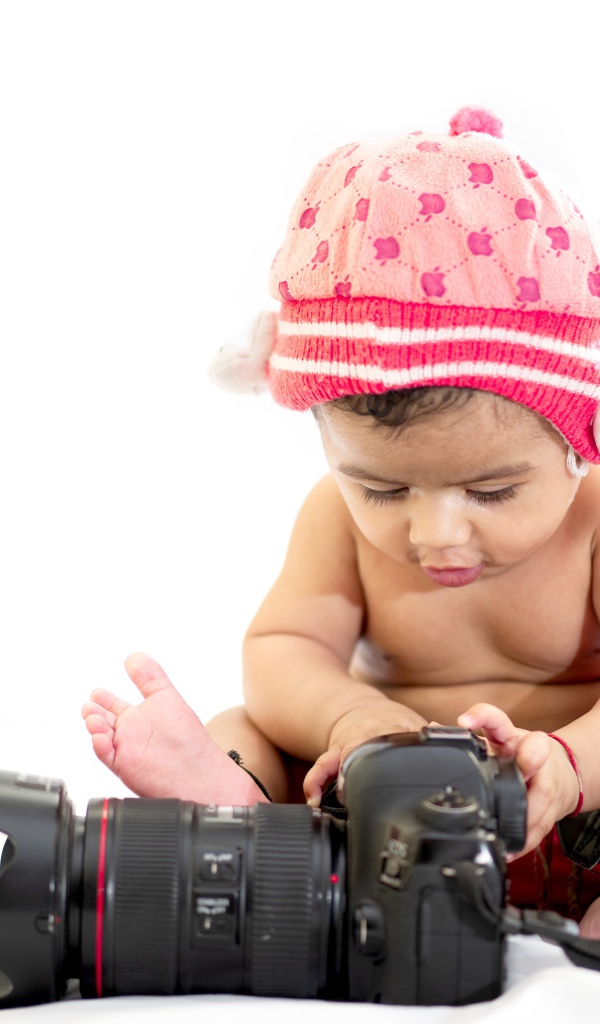 Маленький ребенок с фотоаппаратом на белом фоне 