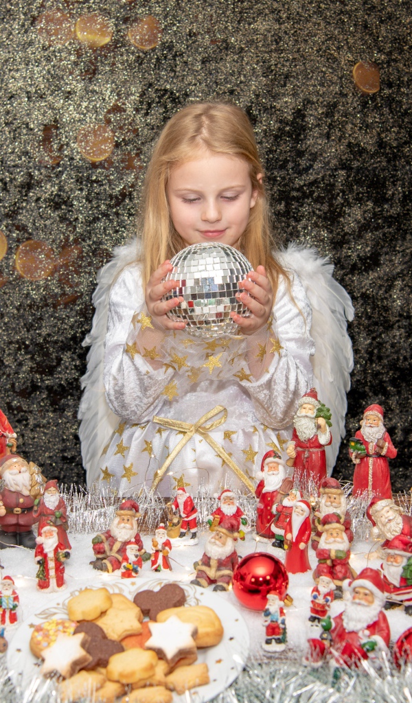 Маленькая девочка в костюме ангела с новогодним декором