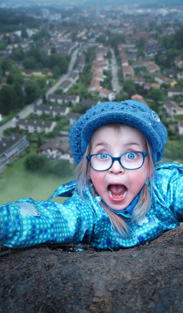 Маленькая девочка в голубом костюме на горе 