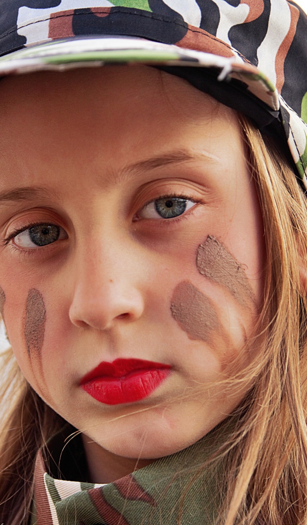 Маленькая девочка в кепке с грязью на лице