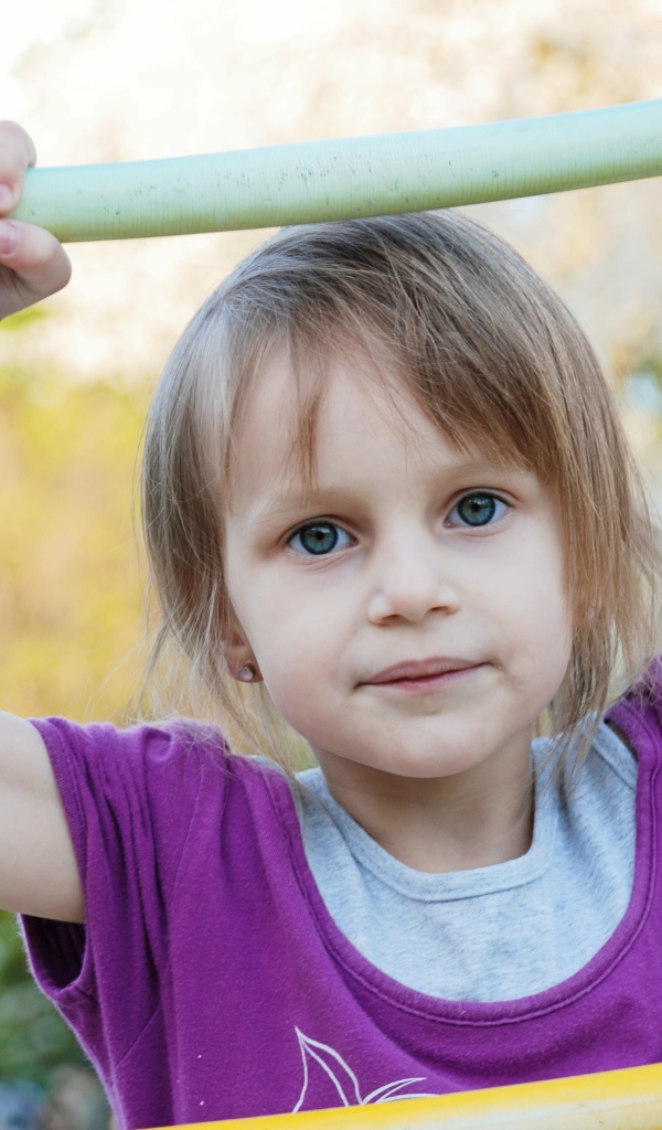 Маленькая девочка на подвесной лестнице 