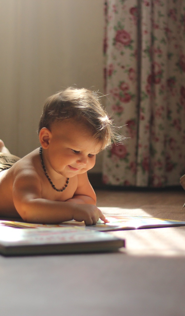 Маленькая девочка с книгами на полу в комнате