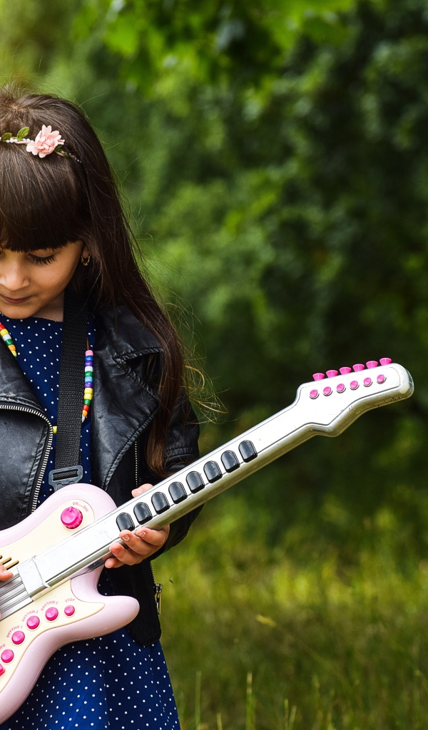 Маленькая девочка с игрушечной гитарой