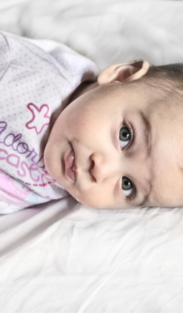 Маленький новорожденный ребенок лежит на кровати 