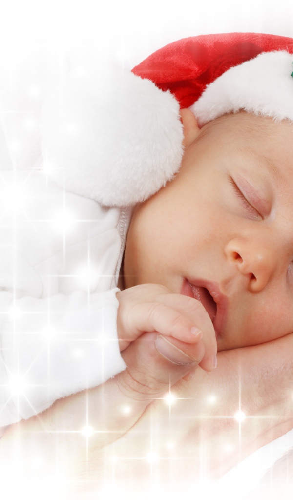 Маленький спящий ребенок в новогодней шапке 