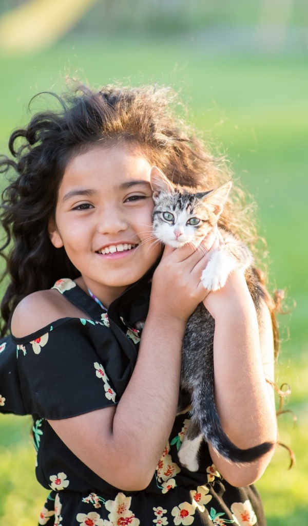 Маленькая улыбающаяся девочка с котенком в руках