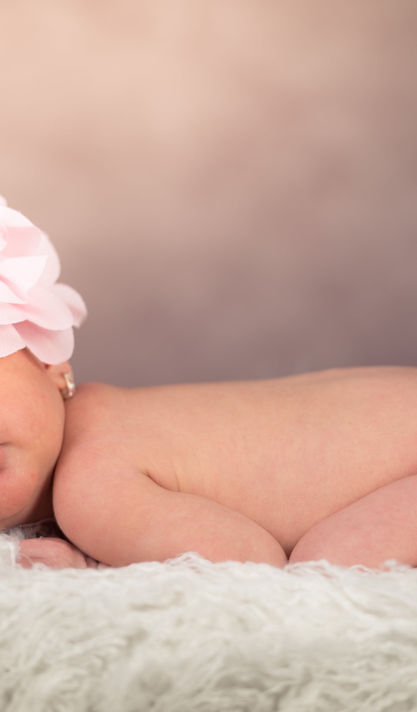 Новорожденная девочка с большим цветком на голове 