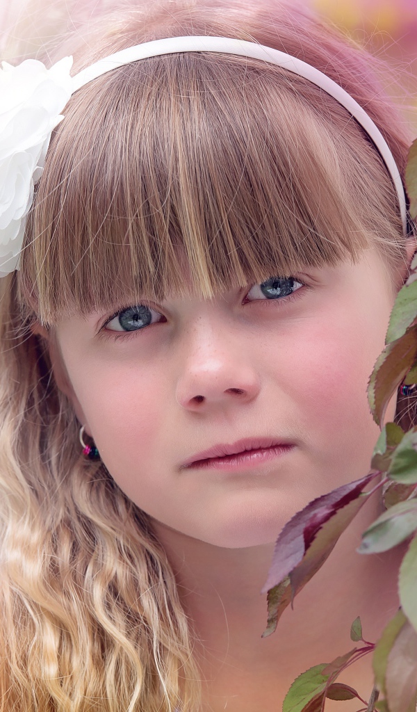 Грустная маленькая девочка у ветки дерева 