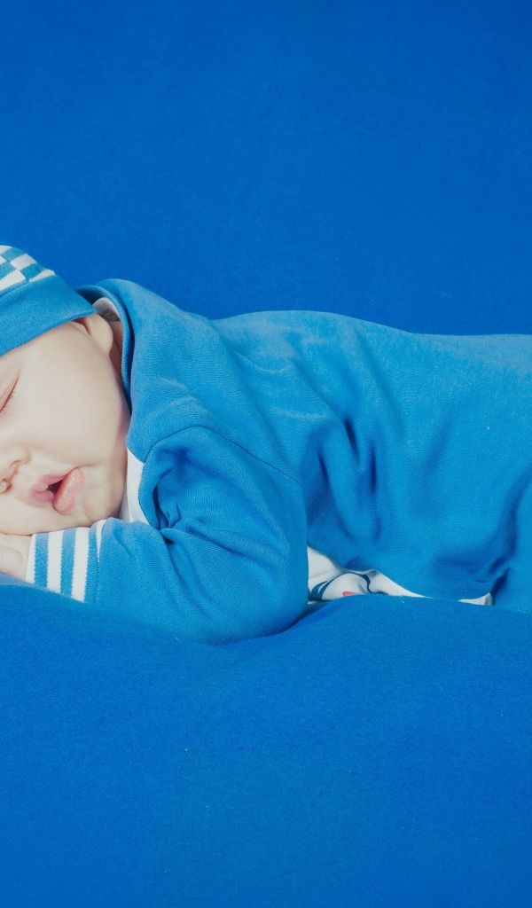 Спящий грудной ребенок в голубом костюме 