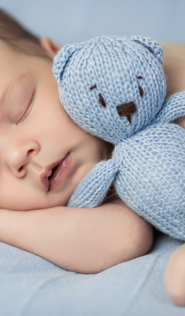 Маленький грудной ребенок с вязаным мишкой