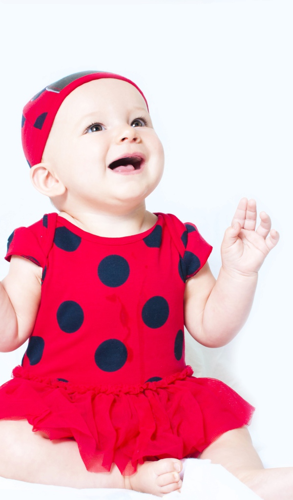 Улыбающаяся девочка в красном платье с черными кругами