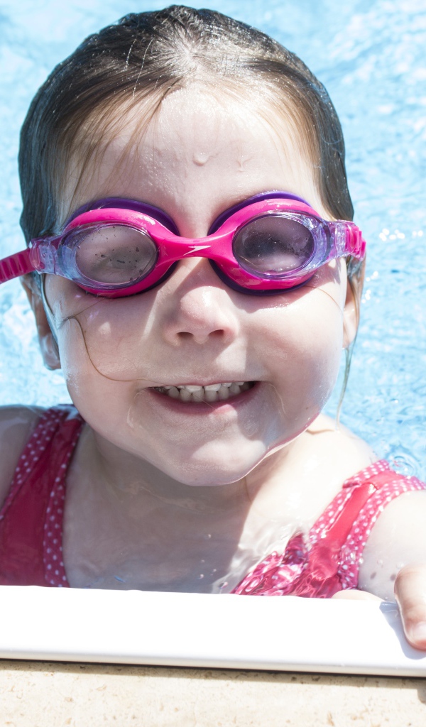 Улыбающаяся девочка в очках в бассейне