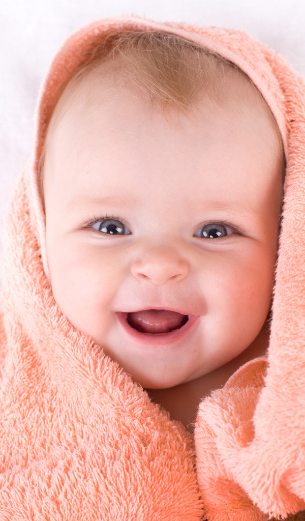 Улыбающийся грудной ребенок в полотенце