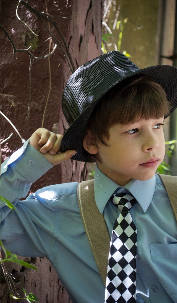 Стильный мальчик в черной шляпе 