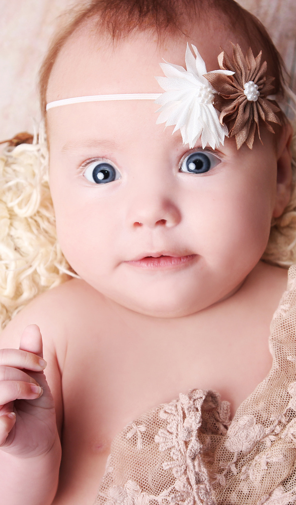 Удивленная голубоглазая новорожденная девочка 