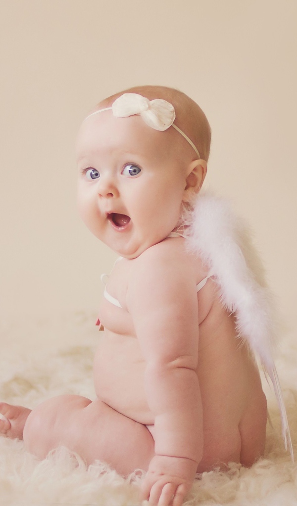 Удивленный грудной ребенок с белыми крыльями за спиной 