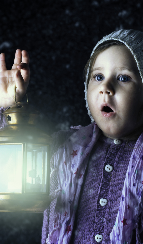 Удивленная маленькая девочка с фонарем в руке