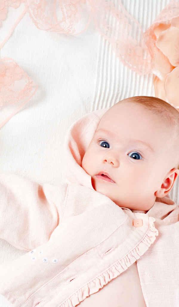 Удивленный новорожденный ребенок с цветком