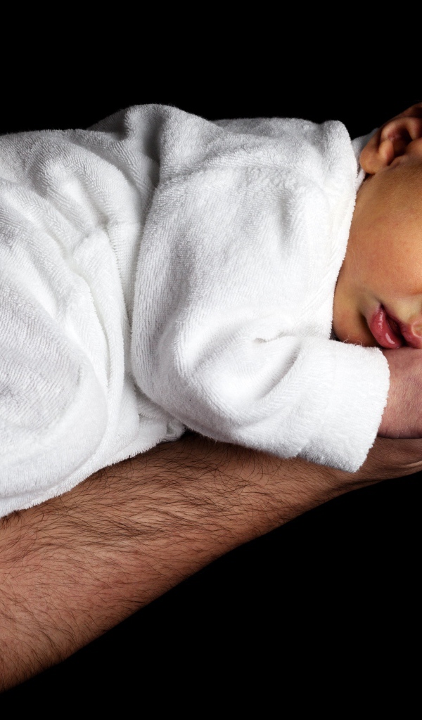 Грудной ребенок спит на руке у папы