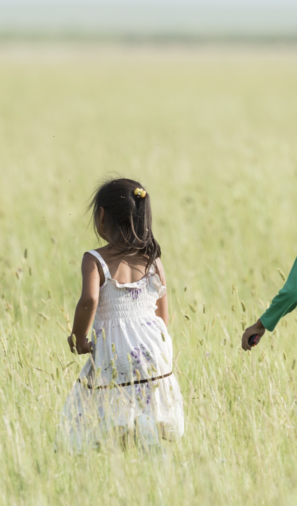 Две маленькие девочки гуляют по полю 