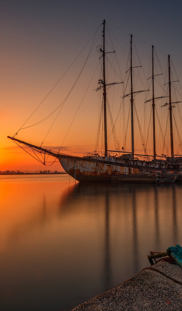 Большой корабль стоит на закате солнца 