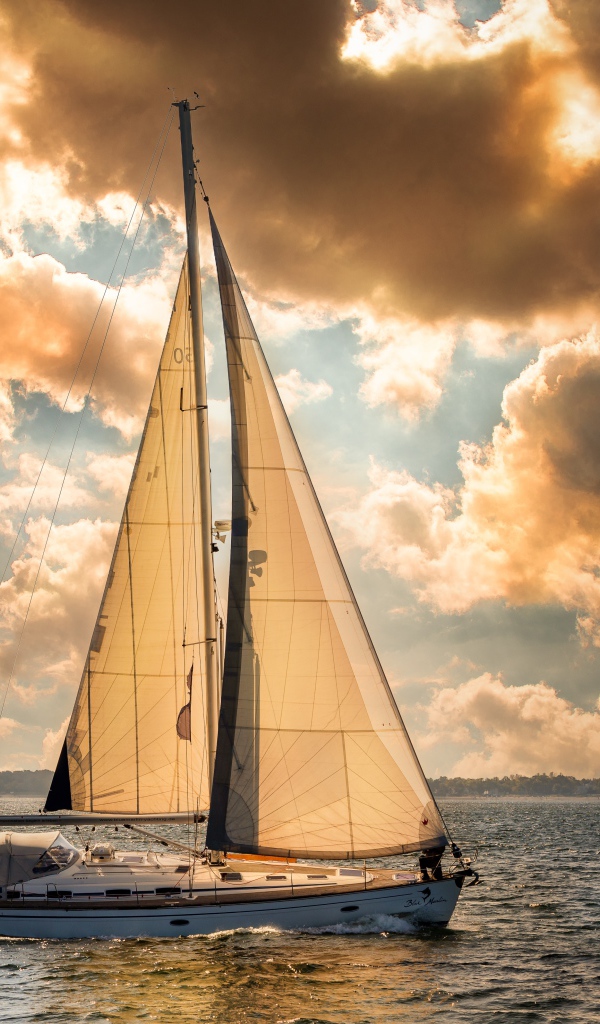 Большая парусная яхта в море на закате 