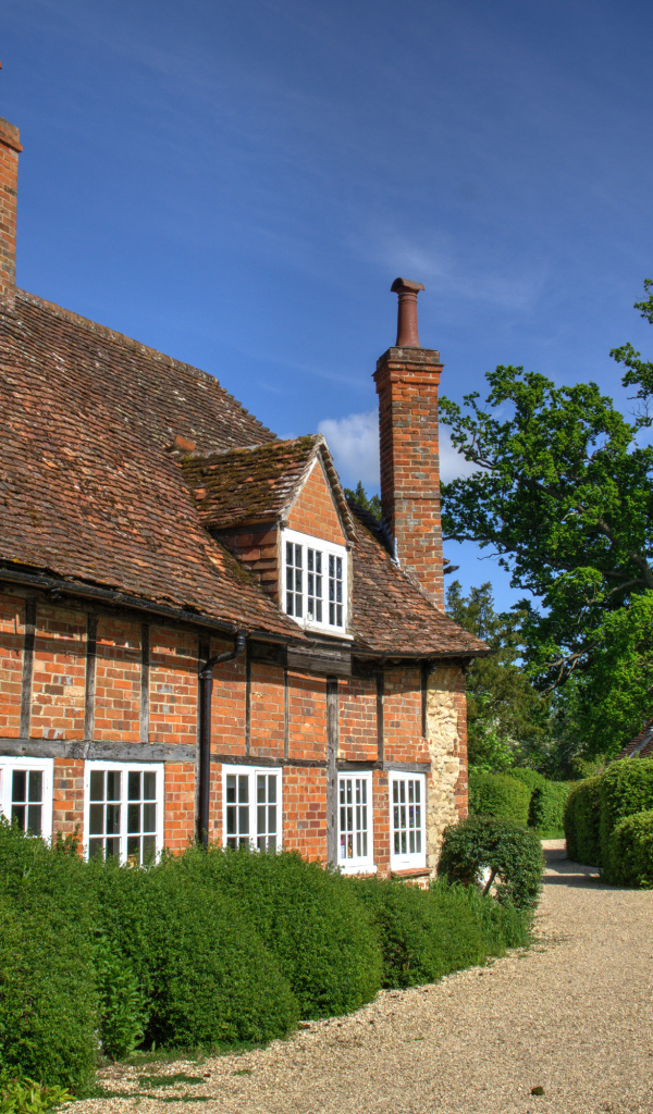 Кирпичный старый дом под голубым небом, Англия 