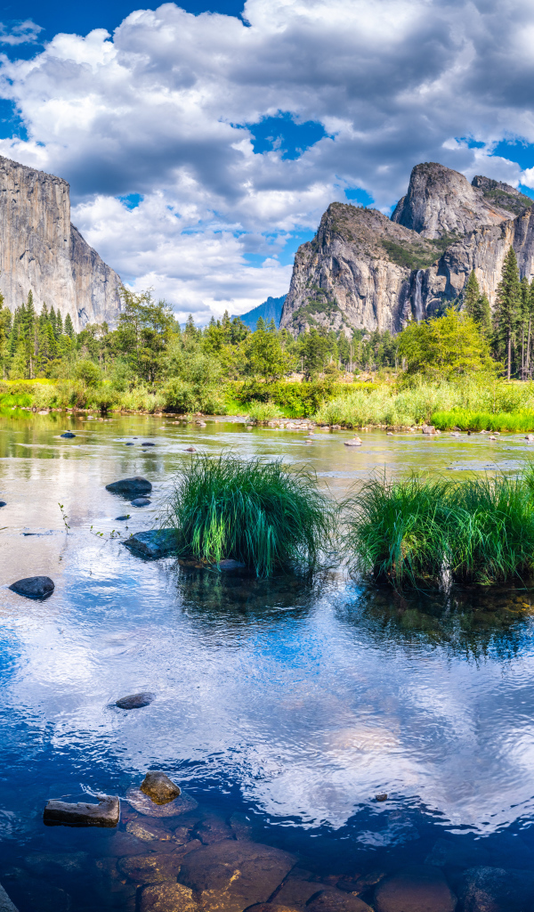 Спокойная вода в озере на фоне гор под белыми облаками, США 