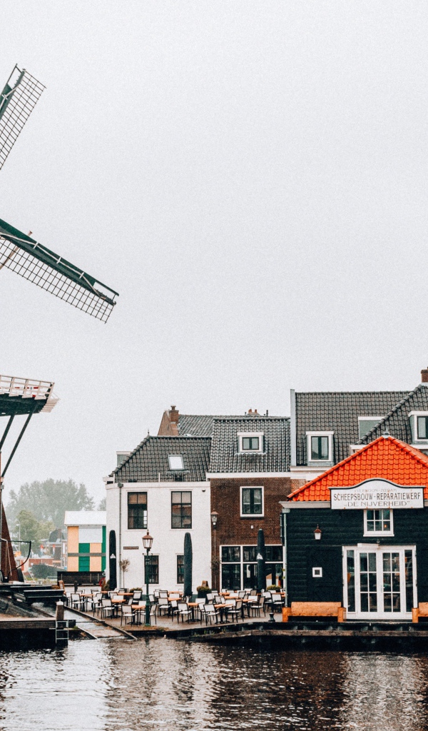 Мельница и дома на берегу реки 