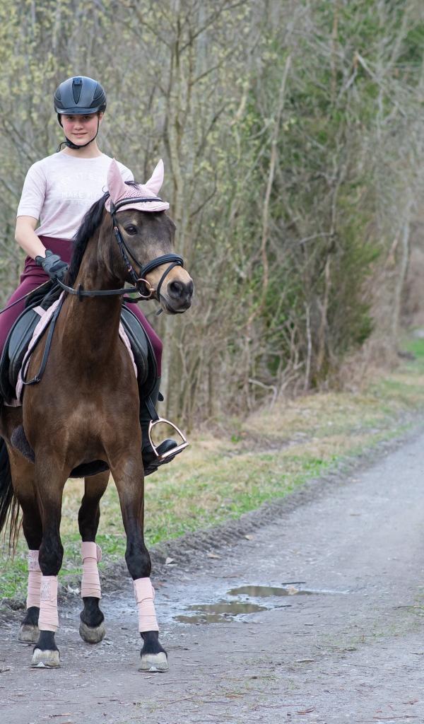Молодая девушка катается на лошади 