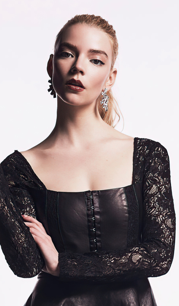 Актриса Аня Тейлор-Джой в черном наряде на белом фоне