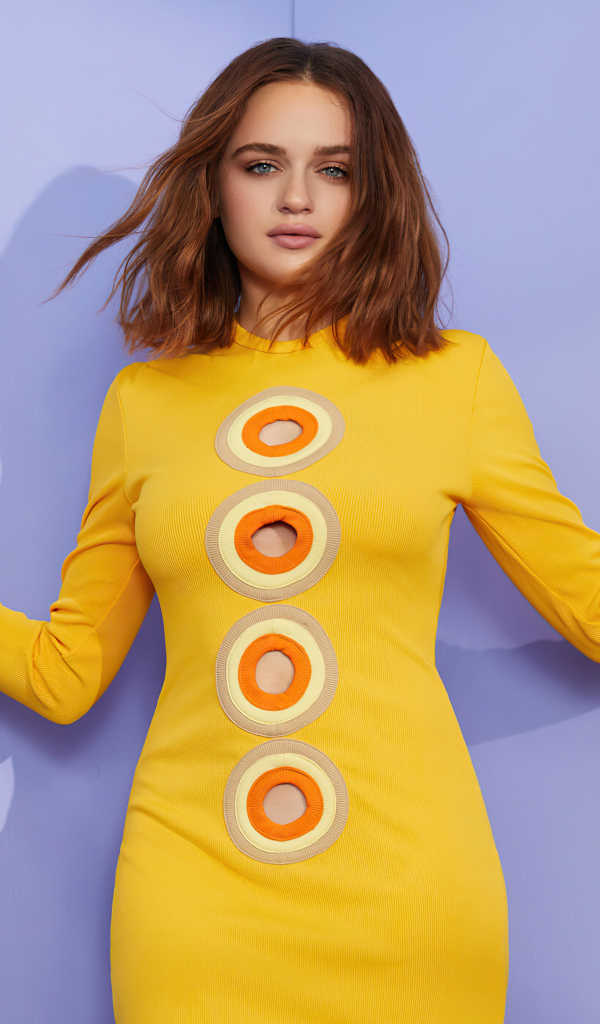 Актриса Джоуи Кинг в желтом платье у стены