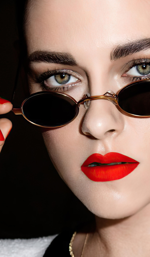 Актриса Кристен Стюарт в очках на  черном фоне