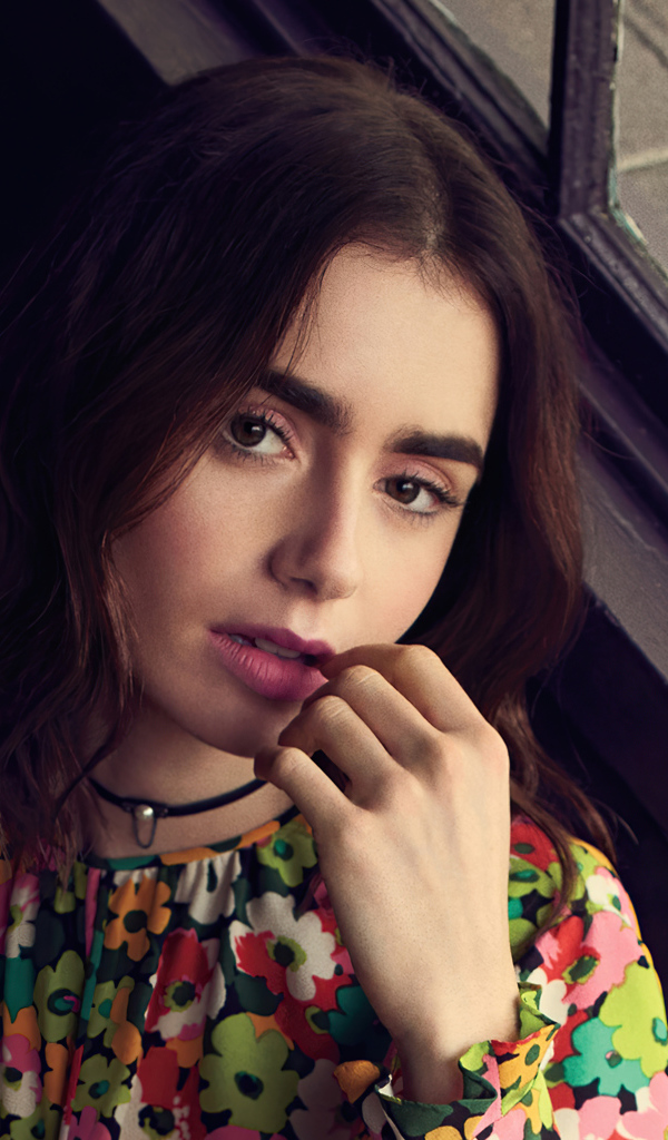 Актриса Лили Коллинз сидит у окна