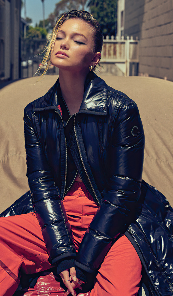 Актриса Оливия Холт в черной куртке сидит на машине