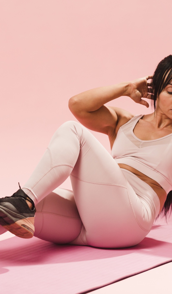 Спортивная девушка качает пресс на коврике