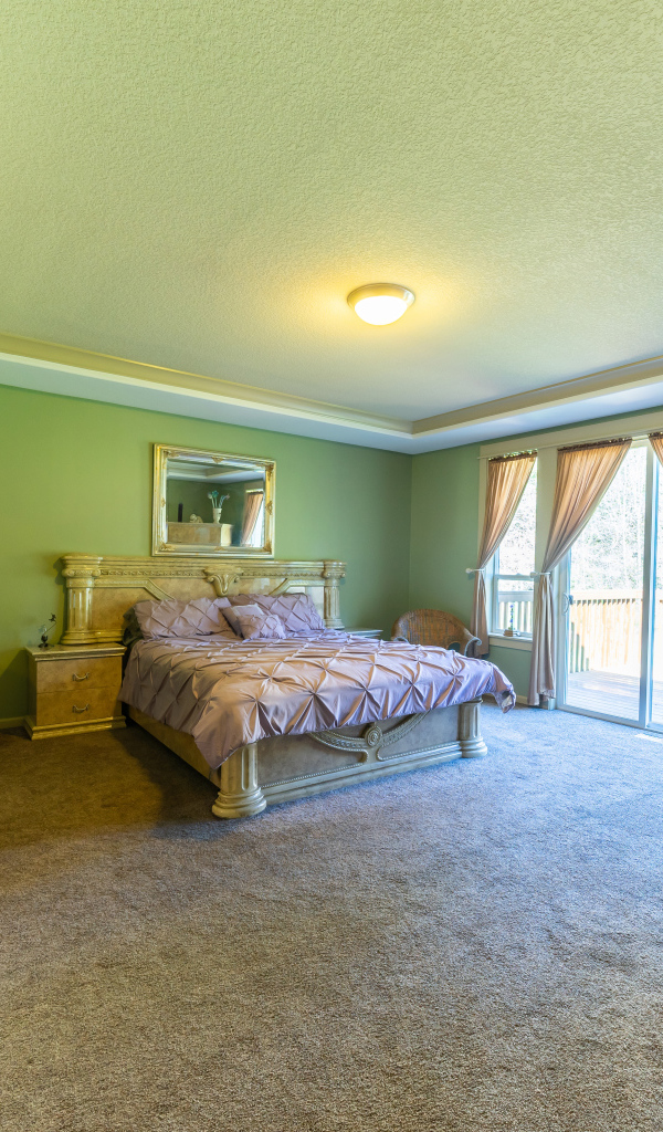 Красивая большая спальня с зелеными стенами 
