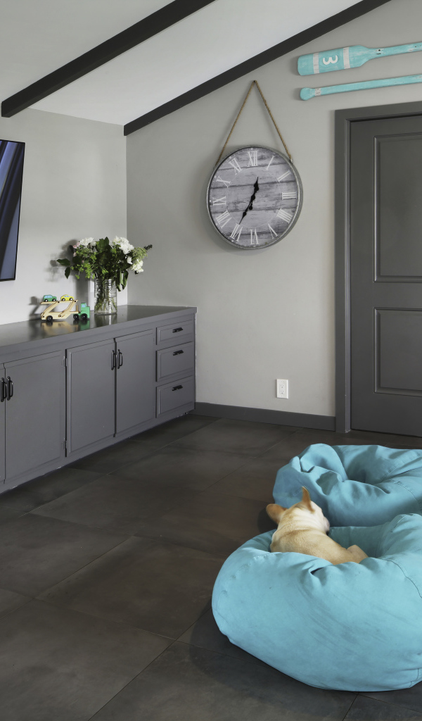 Голубые кресла в комнате с большим телевизором 