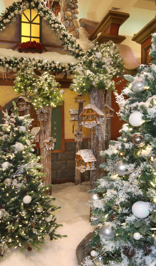 Новогодние ели стоят в комнате с декором 