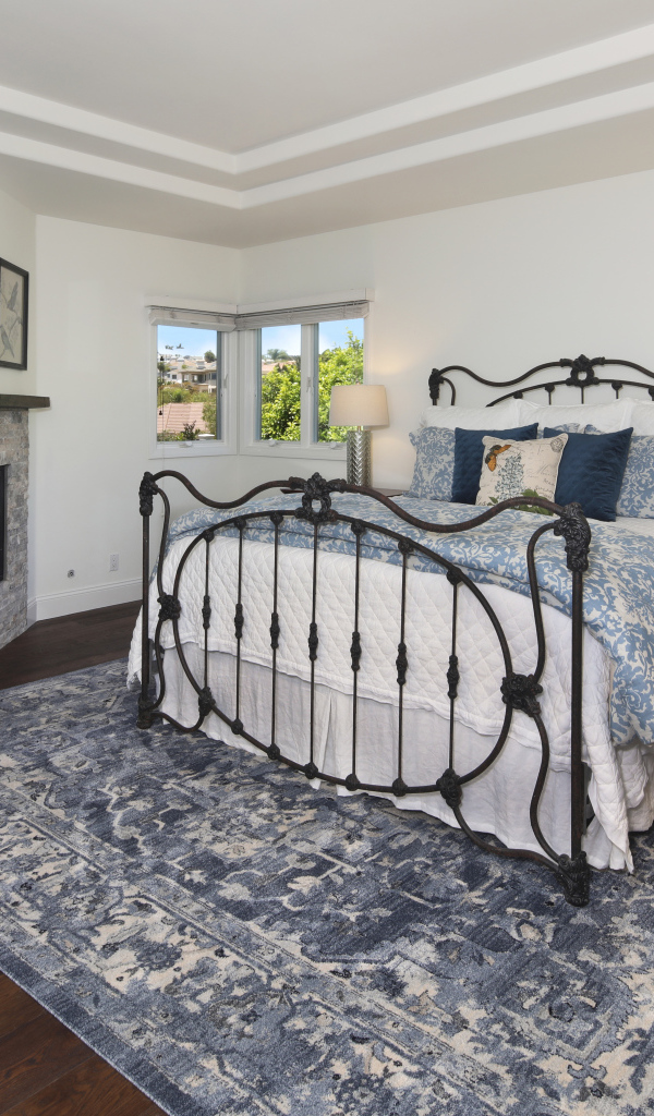 Уютная спальная комната с камином и большой кроватью