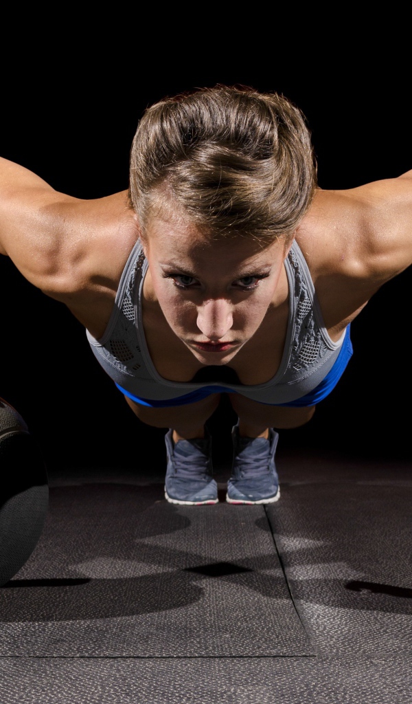 Девушка отжимается с гирями