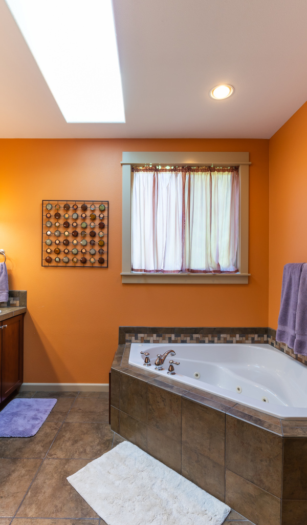 Большая ванная комната с оранжевыми стенами 